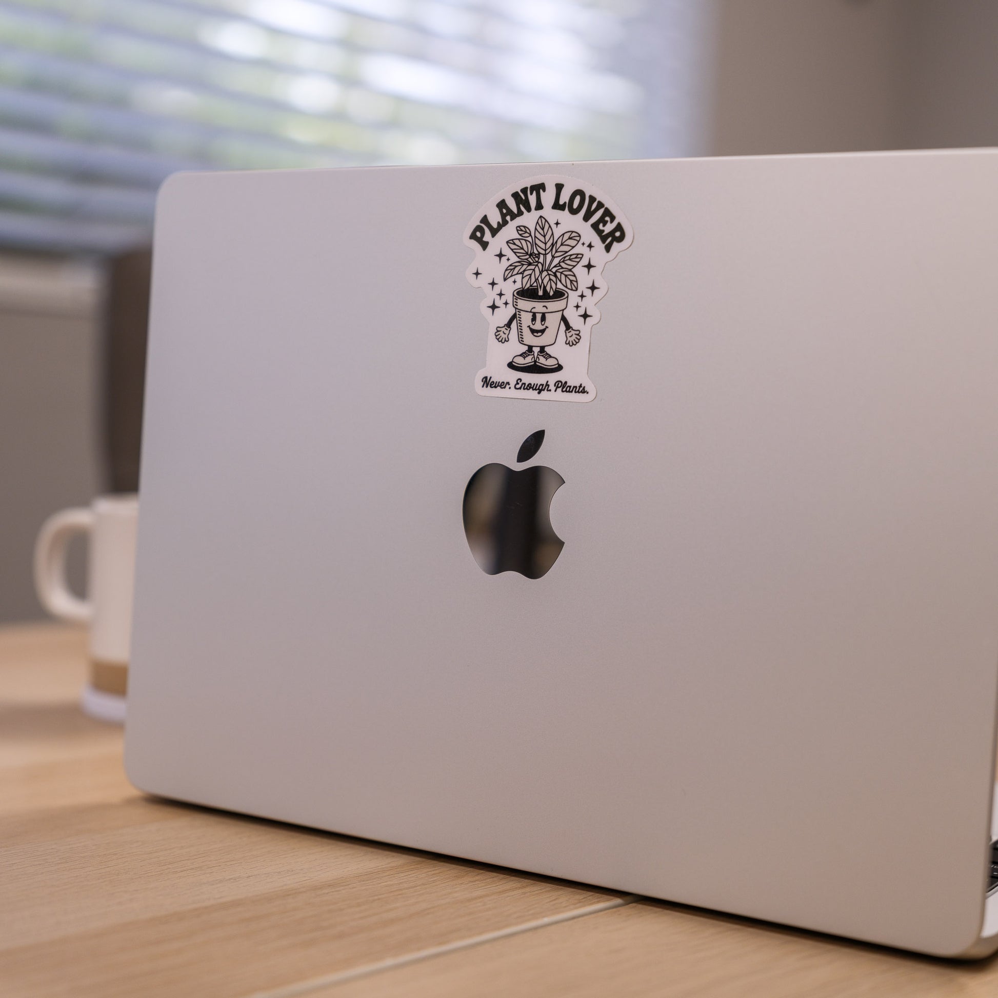 Laptop with a 'Plant Lover' sticker on a wooden desk