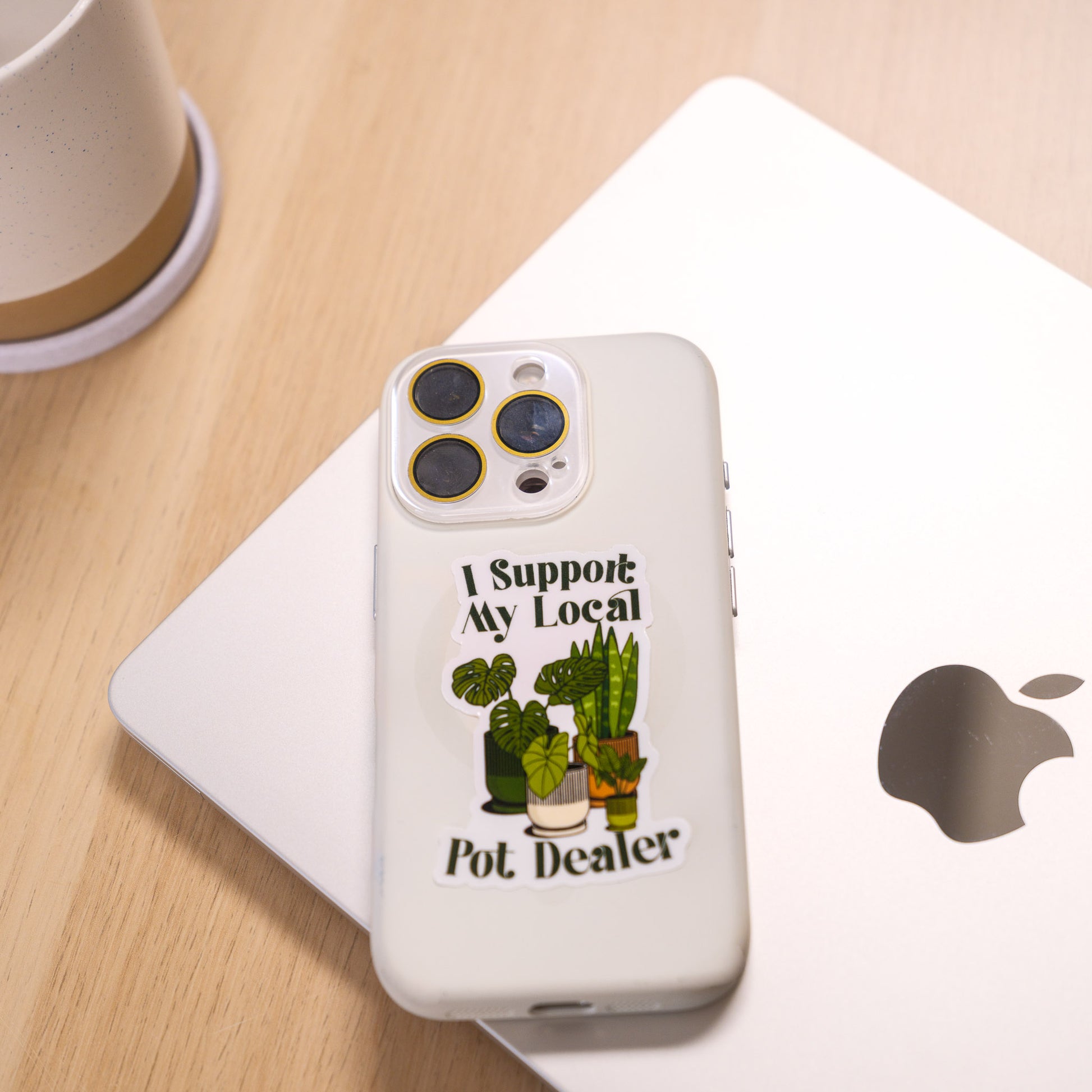 Phone case with 'I Support My Local Pot Dealer' text and plant illustrations on a white surface.